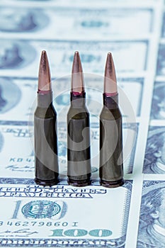 Bullets on US Dollar bills as symbol of bloody business, military conflicts and murders. Vertical image photo