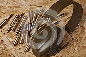 Bullets on wooden texture with hearing protection