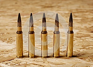 Bullets on wooden texture standing on a row