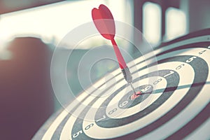 Bulls eye or dart board has red dart arrow throw hitting the center of a shooting target for business targeting