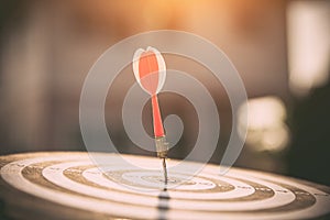 Bullseye or dart board has dart arrow throw hitting the center of a shooting target
