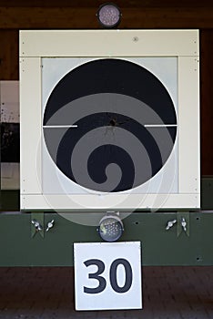 Bullseye target with bullet holes in center, close-up. Gun shooting range