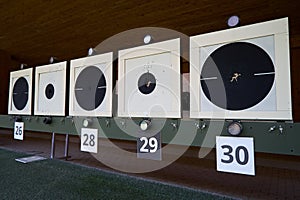 Bullseye target with bullet holes in center, close-up. Gun shooting range