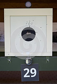 Bullseye target with bullet holes in center, close-up. Gun shooting range