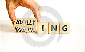 Bullying and belittling symbol. Concept words Bullying and Belittling on wooden cubes. Businessman hand. Beautiful white table