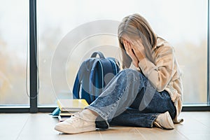 Bullying, discrimination or stress concept. Sad teenager crying in school