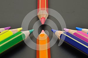 Bullying metaphor with color pencils pointing to red one photo