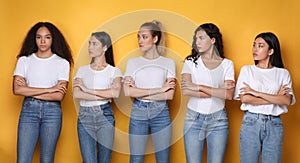 Diverse Women Looking At African Girl Standing Over Yellow Background photo