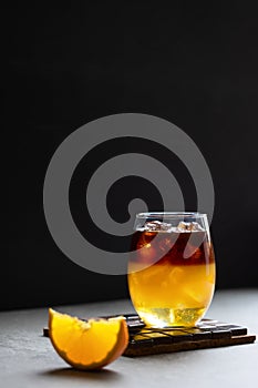 Bumble coffee with layers of espresso, orange juice and syrup on a dark background