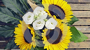 Bumblebee on a bouquet with roses and sunflowers. The background of the outgoing summer.