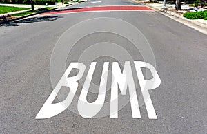 BUMP warning sign painted on residential street surface