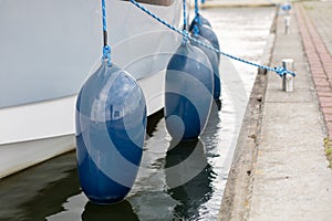 Bumpers hung at the side of the yacht. Moored and secured boats