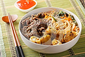 Bun Bo Xao is a Vietnamese noodle salad made with marinated flank steak, vermicelli noodles, vegetables and crispy nem spring