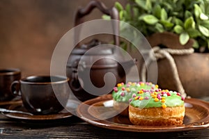 Bun, donut covered with glaze. Tutti frutti bun on a plate. Sweet pastries. Dessert. Still life. Close-up.
