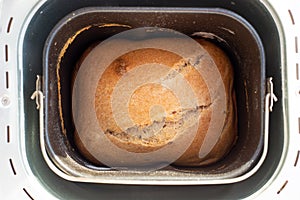 A bun of freshly baked bread in the form of a bread machine. Making homemade cakes