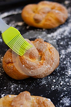 Bun and kithcen brush on the black baking sheet with flour