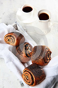 A bun with poppy seeds. Freshly baked buns with poppy seeds on a light background. Vertical photo.