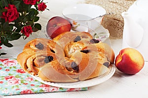 Bun roll with apple and cinnamon raisin in a still life on plate bright