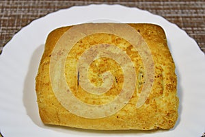 Bun on a white plate on the table.