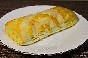 Bun on a white plate on the table.