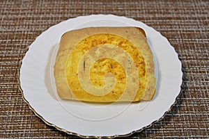 Bun on a white plate on the table.
