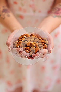 Bunch, almond and nuts in woman hands as a vegetarian for healthy, organic and balanced diet by eating nutritious snacks