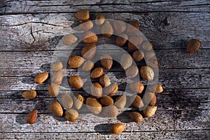 Bunch of almonds unshelled, badam, forest fruit harvest on wood