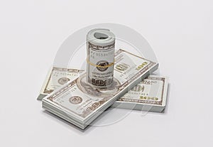 A bunch of American dollars in denominations of 100 dollars notes rolled up and held together with a simple rubber band with two s