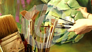 A bunch of art paint brushes on background of professional artist working