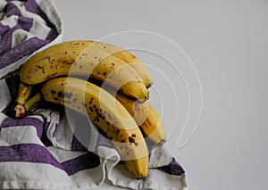 Bunch of bananas with a white and blue cloth and white background with copy space