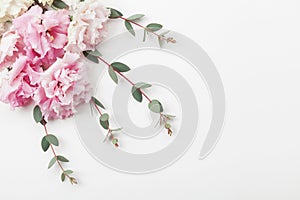 Bunch of beautiful flowers and eucalyptus leaves on white table top view. Flat lay style.