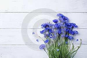 Bunch of blue cornflowers on white wooden table top view