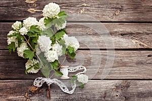 Bunch, bouquet of white flowers with lace on dark aged weathered wooden background