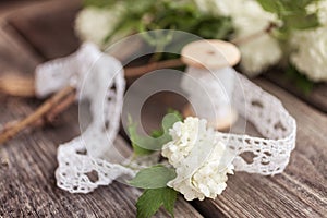 Bunch, bouquet of white flowers with lace on dark aged weathered wooden background