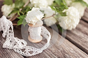 Bunch, bouquet of white flowers with lace on dark aged weathered wooden background