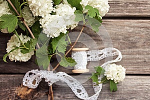 Bunch, bouquet of white flowers with lace on dark aged weathered wooden background