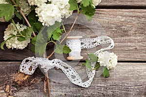 Bunch, bouquet of white flowers with lace on dark aged weathered wooden background