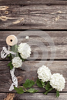 Bunch, bouquet of white flowers with lace on dark aged weathered wooden background