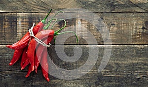Bunch of chillies on rustic wooden background. Copy space