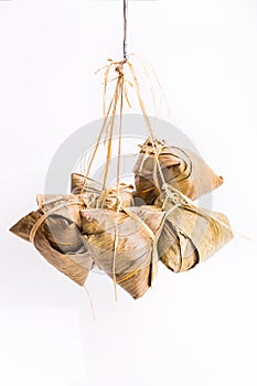 Bunch of Chinese rice dumpling tied hanging against white background in portrait orientation