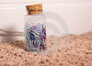 Bunch of colored paper clips in container