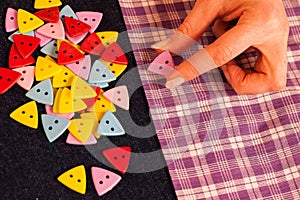 Bunch of colorful buttons in woman's hands over jeans textile