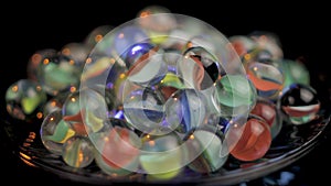 Bunch of Colorful Marble Taw Glass Balls on Spinning Plate Close Up. Vintage Toy