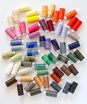 A bunch of colorful threads on a white background