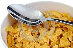 Bunch of corn flake cereals with a metal spoon