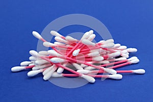 A bunch of cotton buds lie on a blue background.