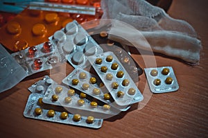 A bunch of different pills and a dressing bandage on the bedside table in a military hospital. Volunteer help. Macro. Soft focus.