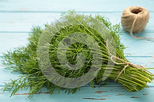 Bunch of dill on blue wooden background with space for text. Top view. Food for vegetarians
