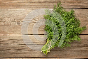 Bunch of dill on grey wooden background with space for text. Top view. Food for vegetarians