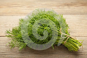 Bunch of dill on grey wooden background. Top view. Food for vegetarians